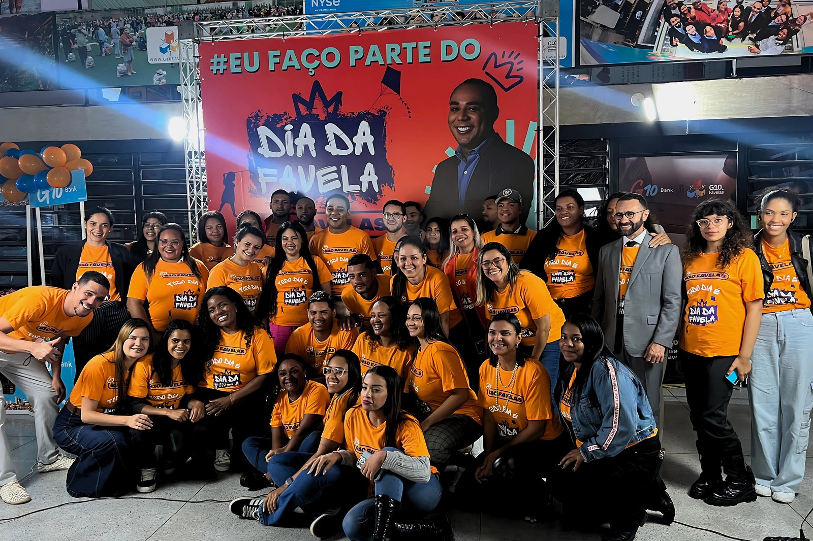 G10 Favelas bloc of leaders and volunteers gathered at Dia da Favela, wearing orange shirts